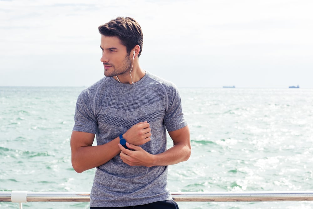 Portrait of a happy sports man standing near sea outdoors Portrait of a happy sports man standing near sea outdoors